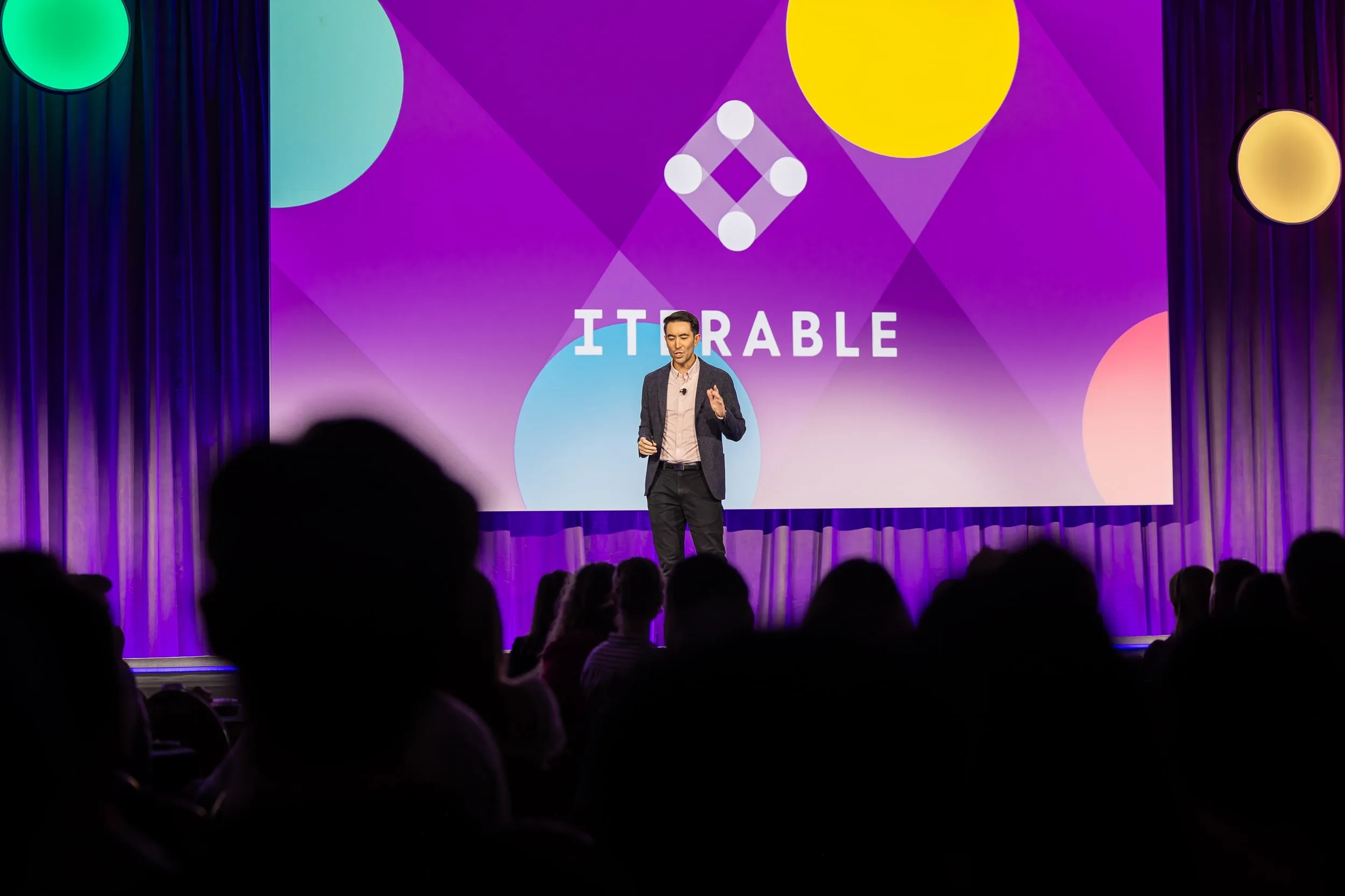 Andrew Boni speaking on stage at Iterable Activate 2024, in front of a purple Iterable backdrop